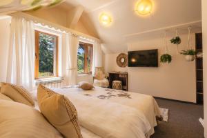 a bedroom with two beds and a tv on the wall at Kuker Hut - Хижа Кукер in Sofia