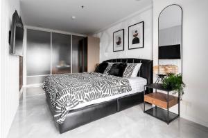 a bedroom with a black and white bed and a mirror at Patong Tower 2-Bedroom Sea View in Patong Beach +10 photos