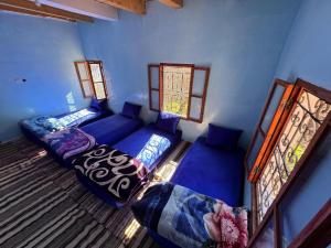 a room with a couch and a bed and windows at Gite Megdaz in Megdaz