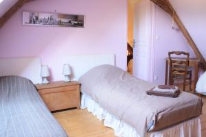 1 dormitorio con 2 camas individuales y 1 silla en Gîte La Poterie, en Jupilles