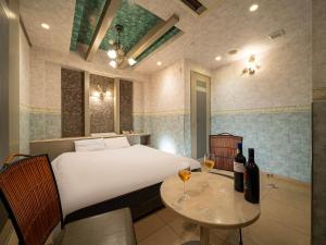 a bedroom with a bed and a table with two glasses of wine at ホテルレジェンドプラス-Adult only in Kyoto +24 photos