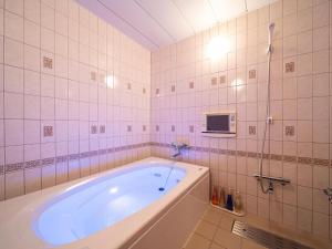 a bath tub in a bathroom with pink tiles at ホテルレジェンドプラス-Adult only in Kyoto