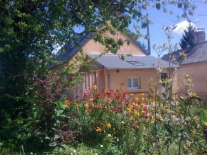 a garden with flowers in front of a house at Gîte La Poterie in Jupilles