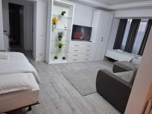 ein Wohnzimmer mit zwei Betten und einem Fernseher in der Unterkunft Apartament Areni Suceava in Suceava