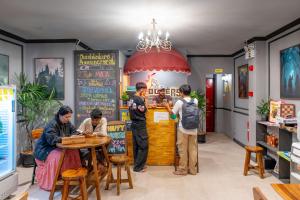a group of people sitting at a table in a restaurant at Whoopers Hostel Chiang Mai - Harry Potter Themed in Chiang Mai