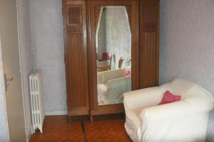 ein Wohnzimmer mit einem Stuhl und einem Spiegel in der Unterkunft Maison Usclade Murat-le-Quaire in La Celle-sous-Gouzon + 1 Foto