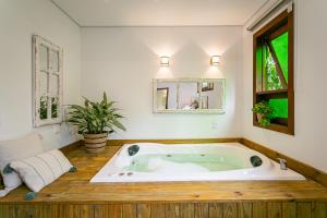 eine große Badewanne im Bad mit Fenster in der Unterkunft Recanto das Palmeiras in Guarda do Embaú