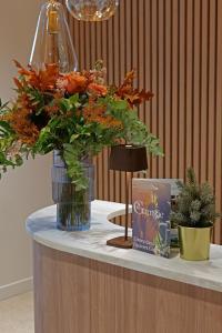 a table with two vases with flowers on it at Garrigae Caserne de Briançon & SPA Cinq Mondes in Briançon