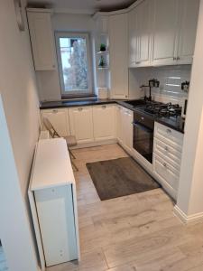 a kitchen with white cabinets and a stove top oven at Apartament Areni Suceava in Suceava