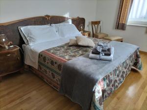a bedroom with a large bed with a wooden headboard at Appartamento l'angelo in Predazzo