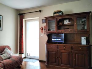a living room with a wooden entertainment center with a tv at Appartamento l'angelo in Predazzo