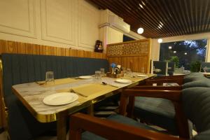 a dining room with a table with plates and chairs at Roots & Peaks Wellness Hotel in Rishīkesh
