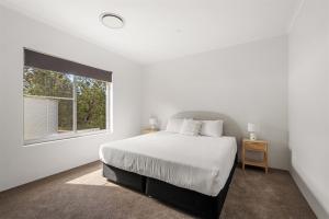 una camera da letto bianca con un letto e una finestra di Bush to Bay - Pet-Friendly Retreat Near Injidup a Yallingup