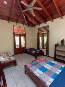 Un dormitorio con dos camas y un ventilador de techo. en Posada Don Javier Mendoza, en Talamanca