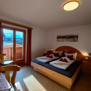 ein Schlafzimmer mit zwei Betten und einem großen Fenster in der Unterkunft B&B Garni Lantschner in Kastelruth
