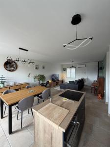 una cucina e un soggiorno con tavolo e sedie di Maison à la campagne a Quarouble