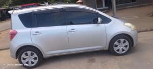 um pequeno carro branco estacionado em uma rua em Izaque Taxi e Viagens em Vila Praia do Bilene