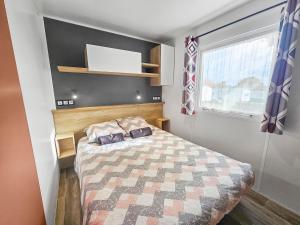 a small bedroom with a bed and a window at L'horizon du bonheur in Litteau