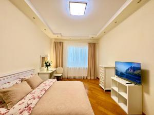 a bedroom with a bed and a flat screen tv at Апартаменты возле метро НАУЧНАЯ in Kharkiv