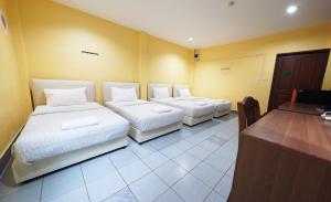 um quarto com duas camas e uma secretária em Excel Hotel Bangkok former Sri Krungthep Hotel em Banguecoque