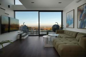 een woonkamer met een bank en een groot raam bij Oasis Pool House 