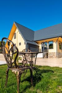 eine Bank, die im Gras vor einem Gebäude sitzt in der Unterkunft Poienărei Forest Heaven in Poenărie