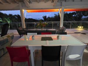 a table and chairs on a patio with a view at Villa Écrin de Nature in Sainte-Rose