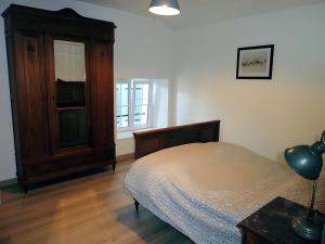a bedroom with a bed and a wooden dresser at Gîte Du Maroye in Montreuil