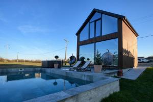 a house with a swimming pool next to a building at Oasis Pool House in Ranilović