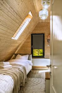 ein Schlafzimmer mit einem großen Bett in einem Zimmer mit Fenster in der Unterkunft Poienărei Forest Heaven in Poenărie + 26 Fotos