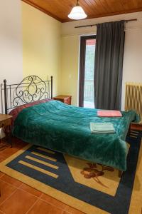1 dormitorio con 1 cama grande y edredón verde en Wood & Chill, en Elevtherokhórion