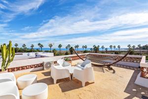 Elle comprend une terrasse dotée d'un mobilier blanc et offrant une vue sur l'océan. dans l'établissement Templo Sotogrande, à Sotogrande