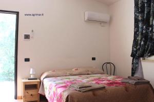 un dormitorio con una cama y una ventana en Agrimar, en Magliano Romano 2 fotos más