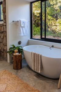 阿马卡拉保护区Induli Lodge - Amakhala Game Reserve的带窗户的浴室里的白色浴缸