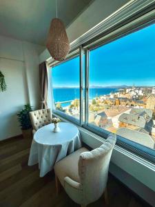 a room with a table and chairs and a large window at Studio vista al lago in San Carlos de Bariloche