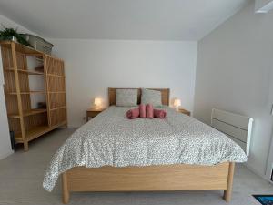 ein Schlafzimmer mit einem Bett mit zwei rosa ausgestopften Tieren in der Unterkunft Le Nid des Frênes - Studio au Cœur de la Nature in Boersch