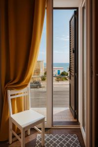 a white chair sitting in front of a window at Marine Case Vacanze in Palermo