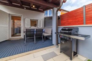 a patio with a grill and a table and chairs at Kuca za Odmor Ena in Jadranovo