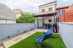 a small backyard with a blue chair on the grass at Kuca za Odmor Ena in Jadranovo