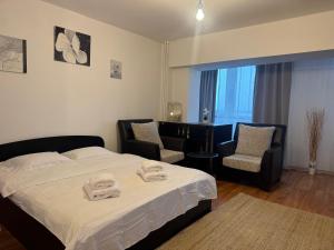a hotel room with a bed and two chairs at Abe Studio in Craiova