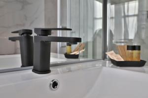een wastafel in de badkamer met een zwarte kraan bij Morina Rooms in Trieste
