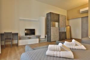 een woonkamer met een bed en een televisie bij Morina Rooms in Trieste