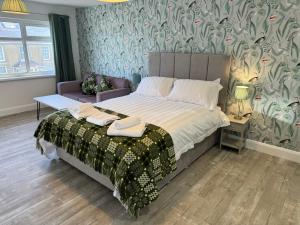 ein Schlafzimmer mit einem Bett mit Blumentapete in der Unterkunft Traeth Rooms in Cardigan