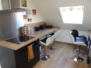 uma cozinha com um balcão e bancos de bar em Bel appartement à 10 minutes du marché de Noël de Strasbourg em Schiltigheim mais 9 fotografias