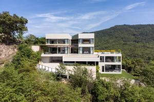 a house on the side of a hill with trees at Sea Breeze Villa in Taling Ngam Beach +66 photos