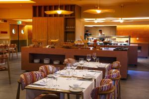 a restaurant with tables and chairs and a kitchen at OZADI Altura Beach Resort - Eurotel Altura in Altura