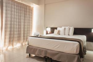 a bedroom with a large bed with a window at Atrium Express Hotels in Parauapebas +84 photos