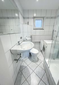 ein weißes Badezimmer mit Waschbecken und Toilette in der Unterkunft 44 - 5 Modern appartement voor 6 personen in Weener