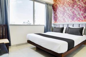a bedroom with a large bed with a large window at Super Collection O Panchvati Regency in Bhopal