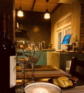 a table with two wine glasses and a bottle of wine at Kay’s Den Kandy in Peradeniya